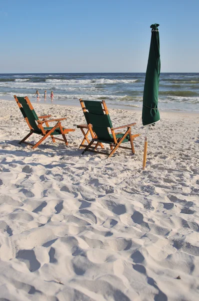 Ein leerer Stuhl und ein Sonnenschirm am Strand — Stockfoto