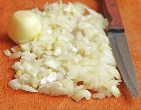 Cipolla tagliata con un coltello sul tagliere — Foto Stock