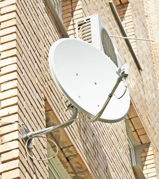 Anteny satelitarnej montowane na mur z cegły — Zdjęcie stockowe