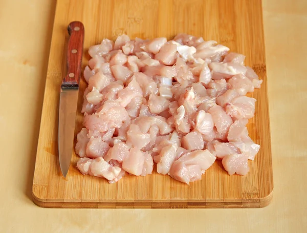 Cutted chicken fillet with knife on a chopping board — Stock Photo, Image