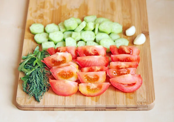 Cutted tomatoes and cucumbers with greens — Stock Photo, Image