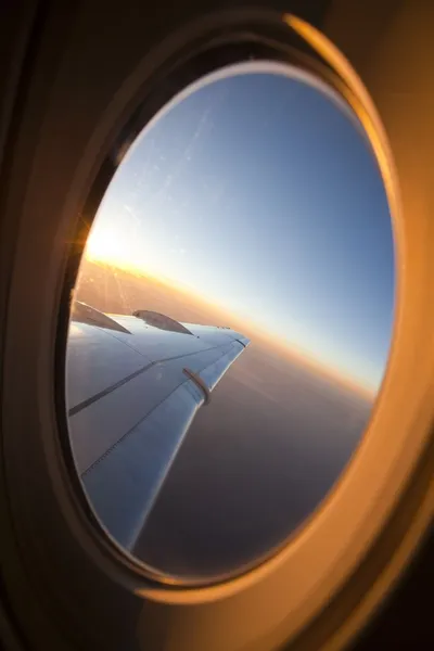Regardant par la fenêtre de l'avion au coucher du soleil — Photo