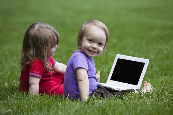 stock image Babies with Notebook sitting on meadow