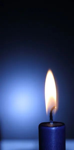Lit vela azul no fundo preto e azul — Fotografia de Stock