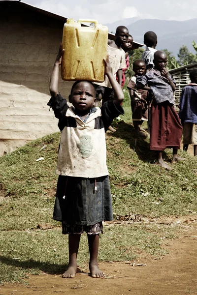 stock image Small african child carrying a jerrycan