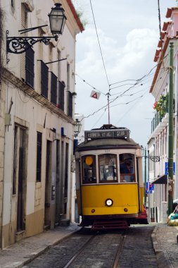 dar sokak içinde sarı tramvay