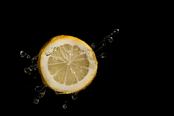 Fatia de limão em um fundo preto — Fotografia de Stock
