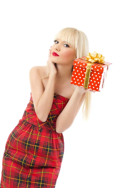 Vacker ung blond flicka håller julklapp i röd klänning — Stockfoto