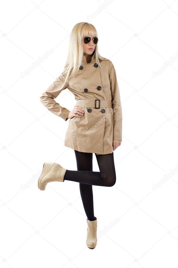 Beautiful blonde young women is posing in a trenchcoat