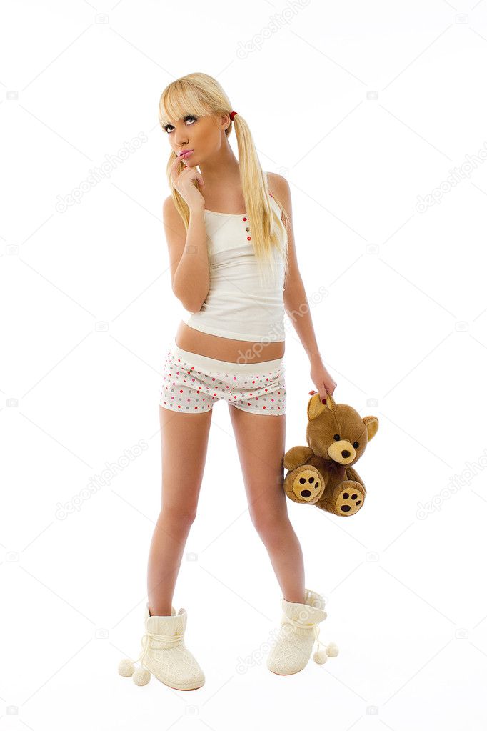 Beautiful cute blonde girl wearing pajamas holding a teddy bear