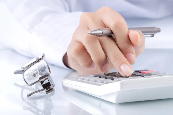 Vrouw handen met een rekenmachine en een pen — Stockfoto