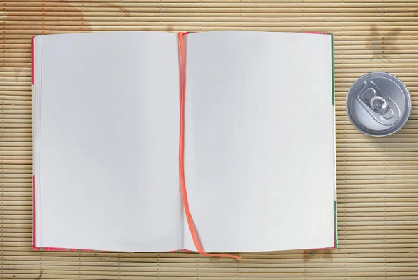 Cuaderno abierto y lata de refresco —  Fotos de Stock