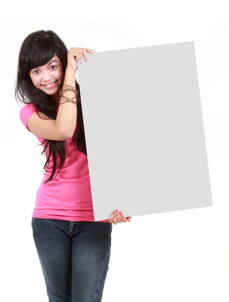 Onnellinen nuori nainen, jolla on tyhjä lauta valkoista taustaa vasten — kuvapankkivalokuva