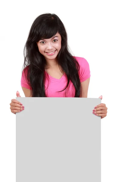 Gelukkig jonge vrouw houden op leeg bord tegen witte pagina — Stockfoto