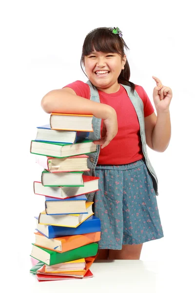 快乐的年轻女孩，和一堆书在她旁边一起笑 — 图库照片