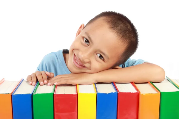 Portrait of young boy leaning on top of his colorful books — Stock Photo, Image