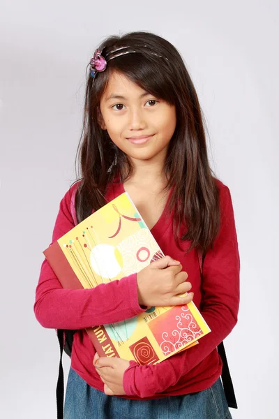 A hátizsák és a könyvek mosolygó lány portréja — Stock Fotó