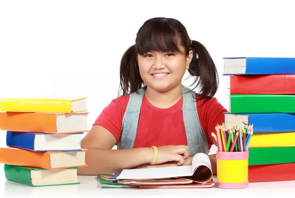 Bilden av skolflicka leende med högen av böcker mot vit — Stockfoto
