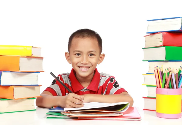 Boldog gyerek mosolyogva, miközben tanul, fehér háttér — Stock Fotó