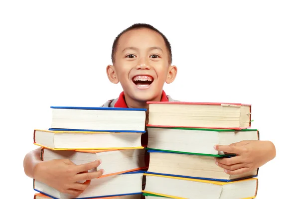 Criança sorrindo com livro no peito — Fotografia de Stock