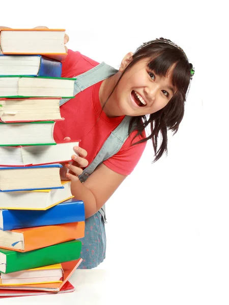 Hromadu knihy s rozkošné dítě za ním s úsměvem — Stock fotografie