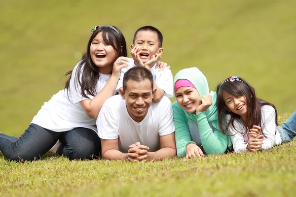 Šťastná rodina, usmíval se v parku — Stock fotografie