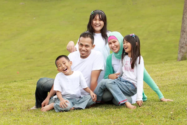 Feliz familia sonriendo de una mamá y un papá con sus hijos — Foto de Stock