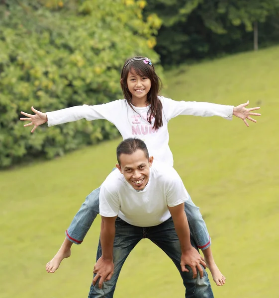 Father giving daughter piggyback ride — Stock Photo, Image