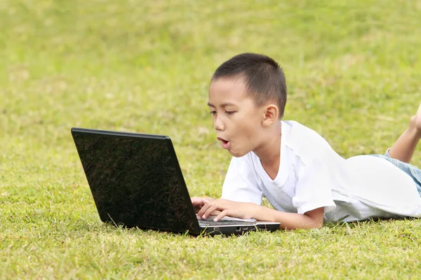 Шокированный ребенок на ноутбуке — стоковое фото