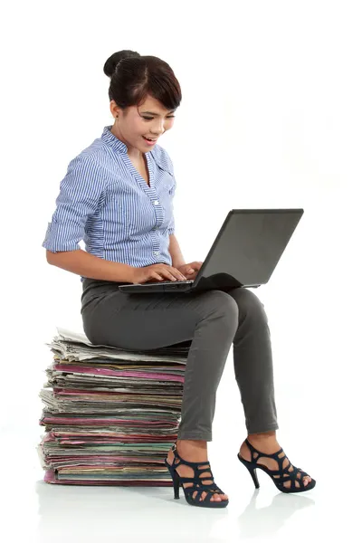 Žena pracující s přenosným počítačem a sedí na zásobníku papírnu — Stock fotografie