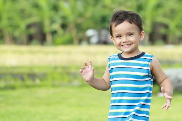 Little boy smiling greeting someone — Stock Photo, Image