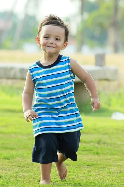 Активний молодий хлопчик посміхається і бігає — стокове фото