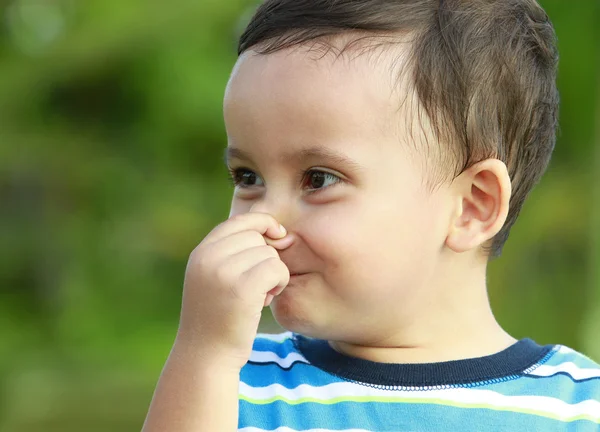 Χαριτωμένο μικρό αγόρι που κρατώντας τη μύτη του — Φωτογραφία Αρχείου
