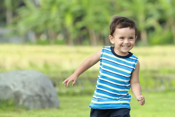 Pequeño niño corriendo en la naturaleza verde — Foto de Stock