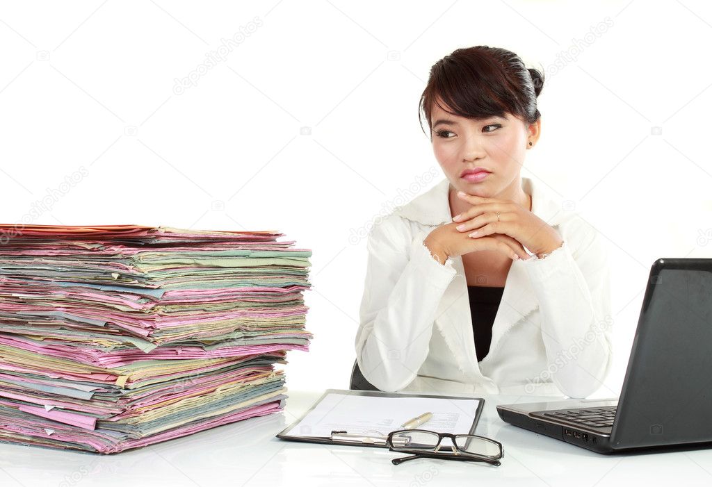 Young business woman with laptop and many paper