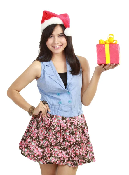 Teen girl in Santa hat presenting gift — Stock Photo, Image