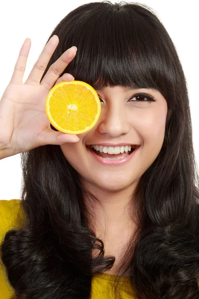 Женщина держит лимоны до глаз и улыбается . — стоковое фото
