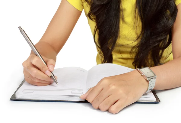 Närbild av en tjej som skriver i en anteckningsbok — Stockfoto