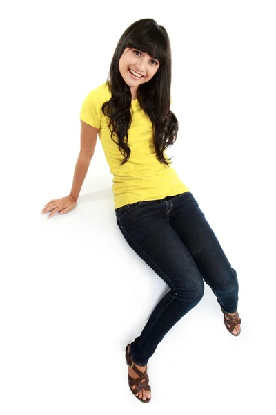 Asiática chica en jeans sentado en la blanca mesa — Foto de Stock
