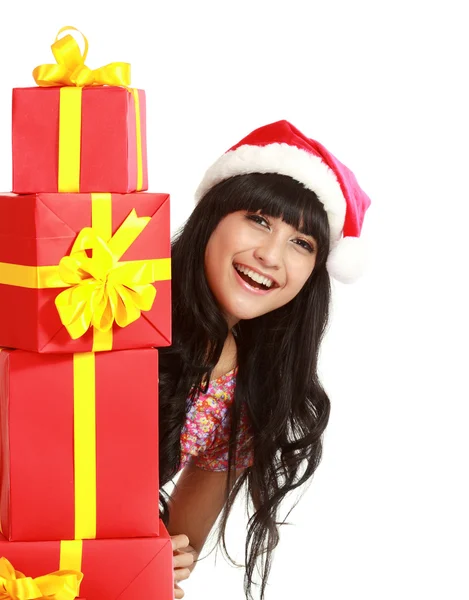 Santa žena nakupování, drží mnoho dárky nosí santa klobouk smili — Stock fotografie