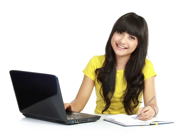 Menina com laptop e escrever em um livro — Fotografia de Stock
