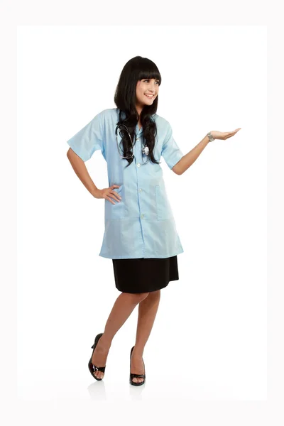 Lächelnde Krankenschwester präsentiert leeren Kopierraum für Produkt oder Text. — Stockfoto