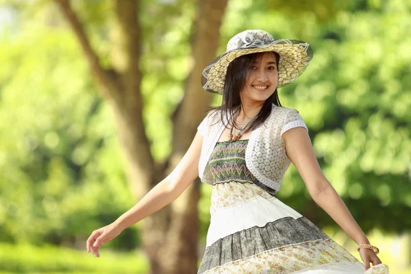 Šťastná mladá žena s úsměvem v parku — Stock fotografie