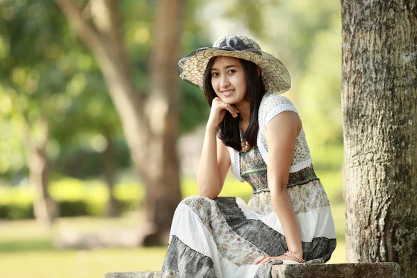 Νεαρός χαμογελαστό ασιατική γυναίκα που κάθεται εξωτερική — Φωτογραφία Αρχείου