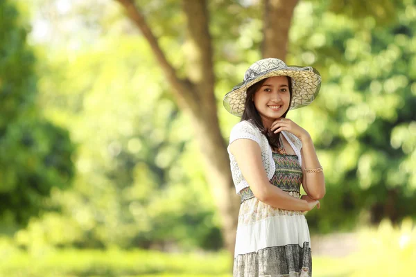 Piękna młoda kobieta uśmiechając się w parku — Zdjęcie stockowe