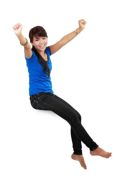 Happy young woman in casual wear sitting with raised arms smilin — Stock Photo, Image