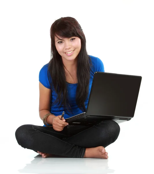 Νεαρή casual γυναίκα που κάθεται κάτω από το χαμόγελο εκμετάλλευση lap-top — Φωτογραφία Αρχείου