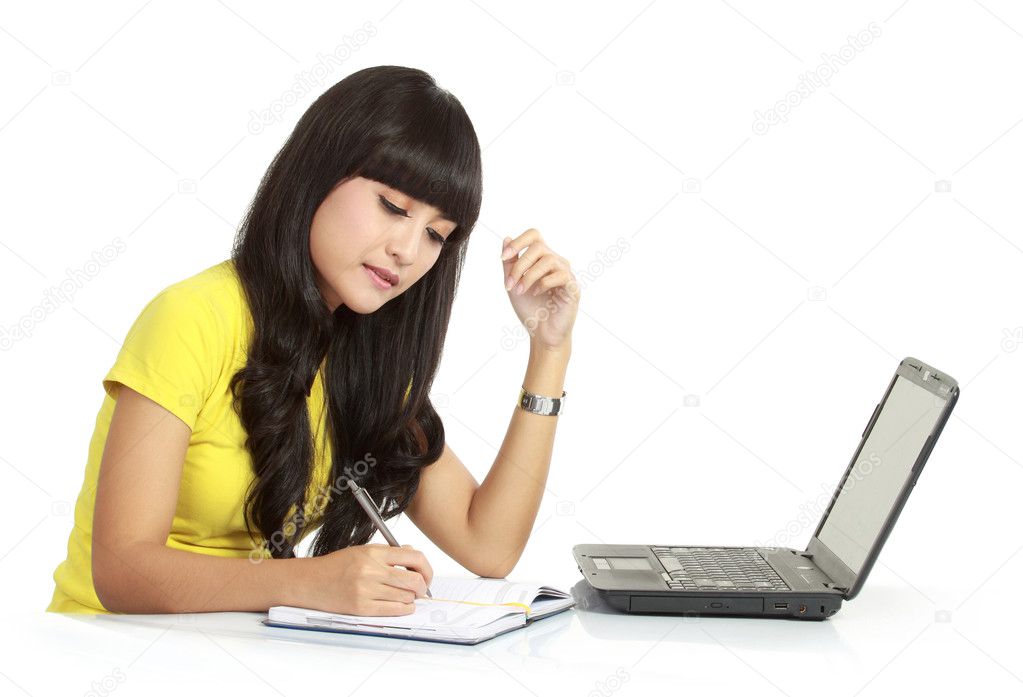 Mädchen mit Laptop und auf einem Buch schreiben Mädchen mit Laptop und auf einem Buch schreiben