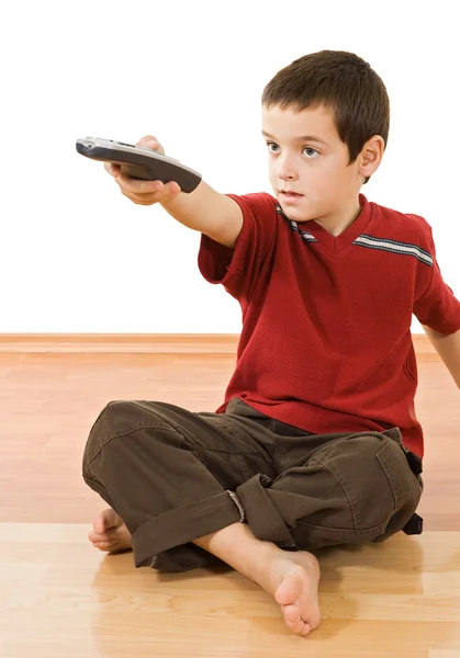Niño pequeño con un control remoto de televisión — Foto de Stock