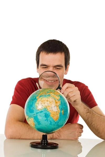 Человек смотрит на глобус Стоковая Картинка